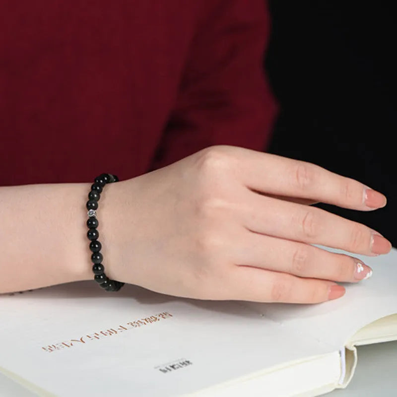 Natural obsidian beaded bracelet with S925 silver flower charms and dragon phoenix constellation design.