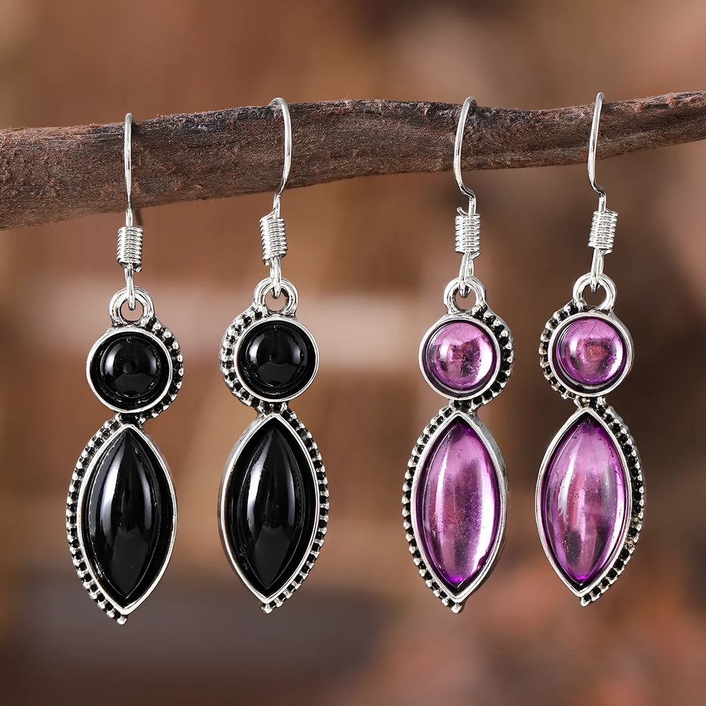 A pair of black and purple vintage geometric drop earrings with a round detail, shown against a plain background.
