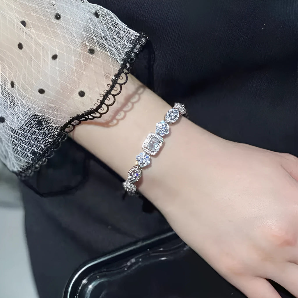 Close-up of women's geometric silver bracelet with sparkling cubic zirconia stones on a wrist, showing adjustable clasp.