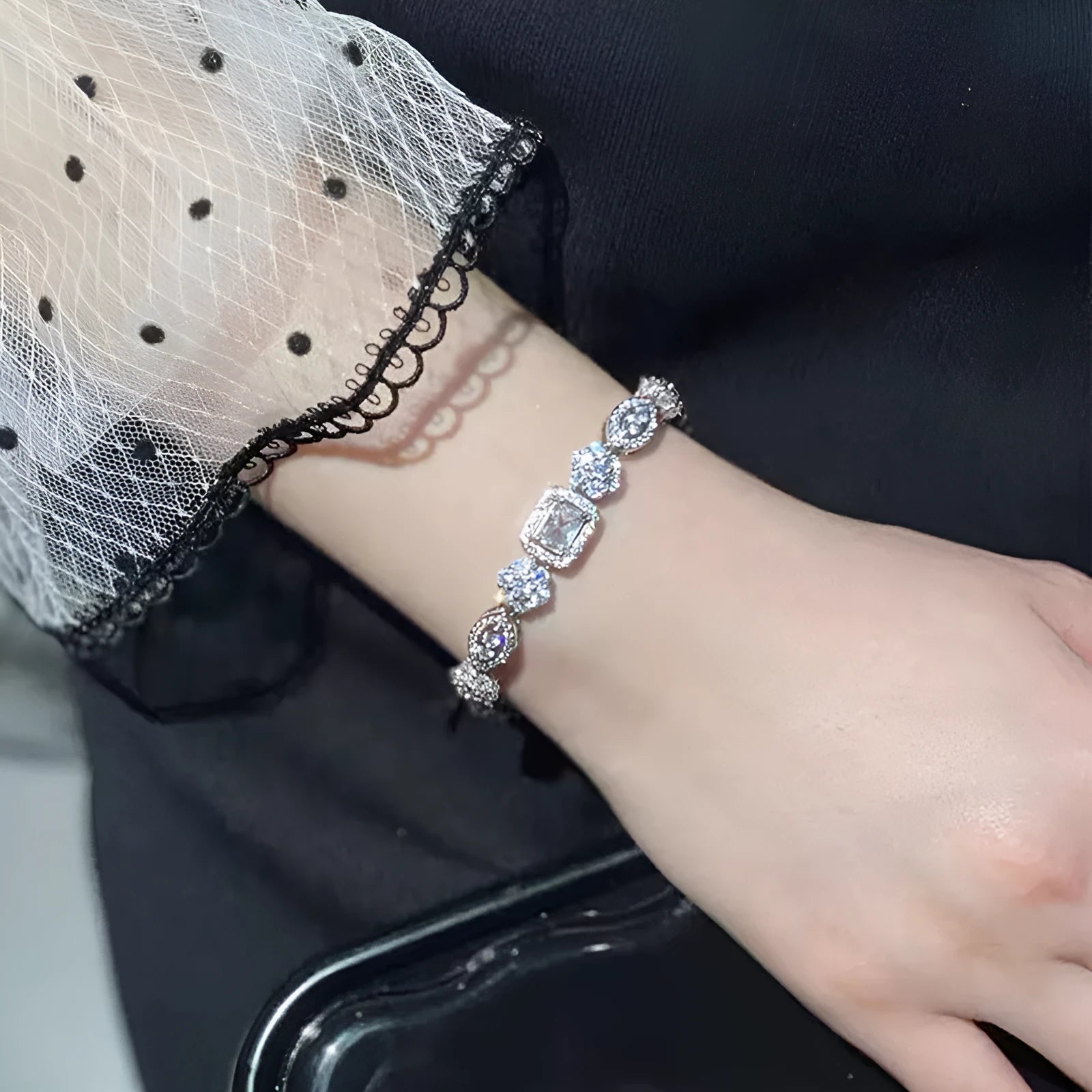 Close-up of women's geometric silver bracelet with sparkling cubic zirconia stones on a wrist, showing adjustable clasp.
