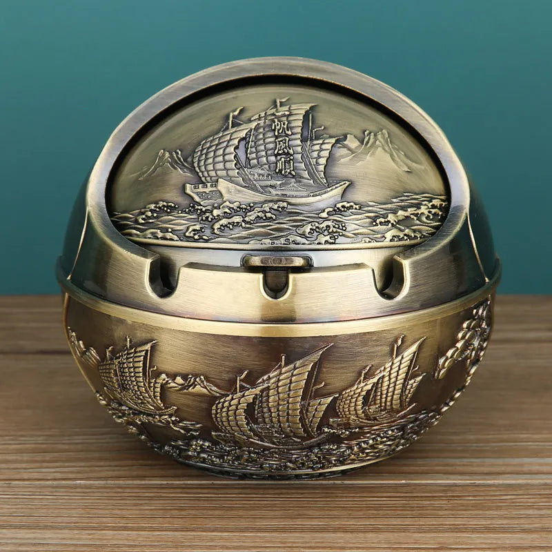 Alloy decorative ashtray in bronze with ornate peacock motif and cigarette extinguishing slot.