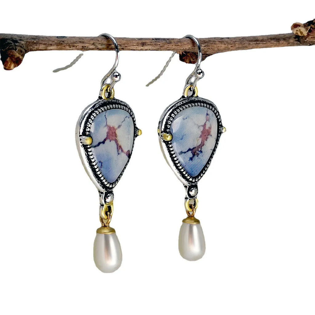 Retro blue geometric drop earrings with synthetic opal and pearl accents on white background