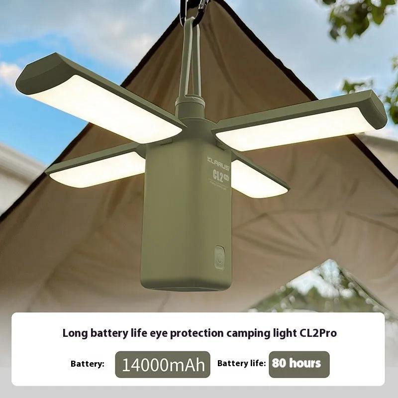 White and green rechargeable LED campsite lamp with charging cable on outdoor picnic table.