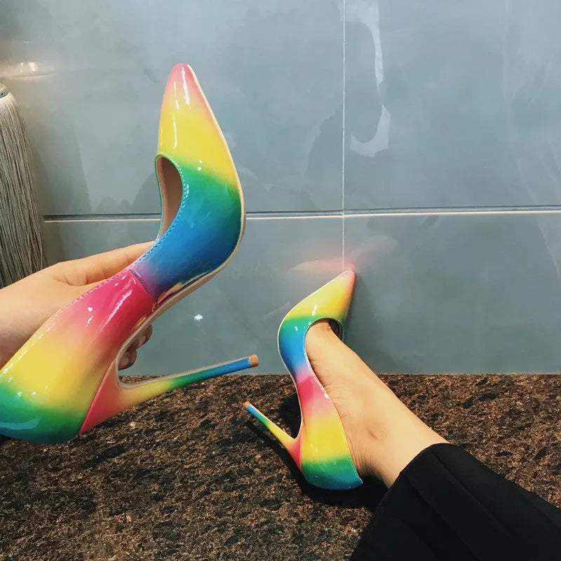 Rainbow coloured patent leather high heel shoes with a pointed toe and a thin stiletto heel.