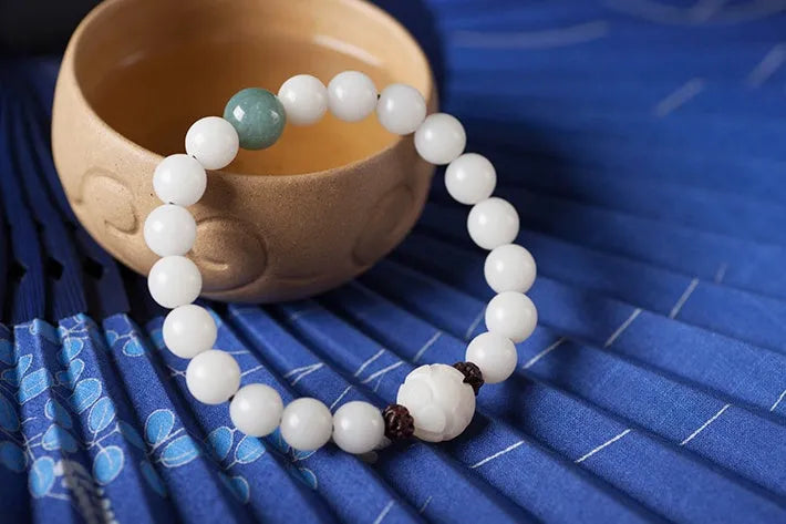 Natural white jade Bodhi bracelet with round beads and transfer bead on white background