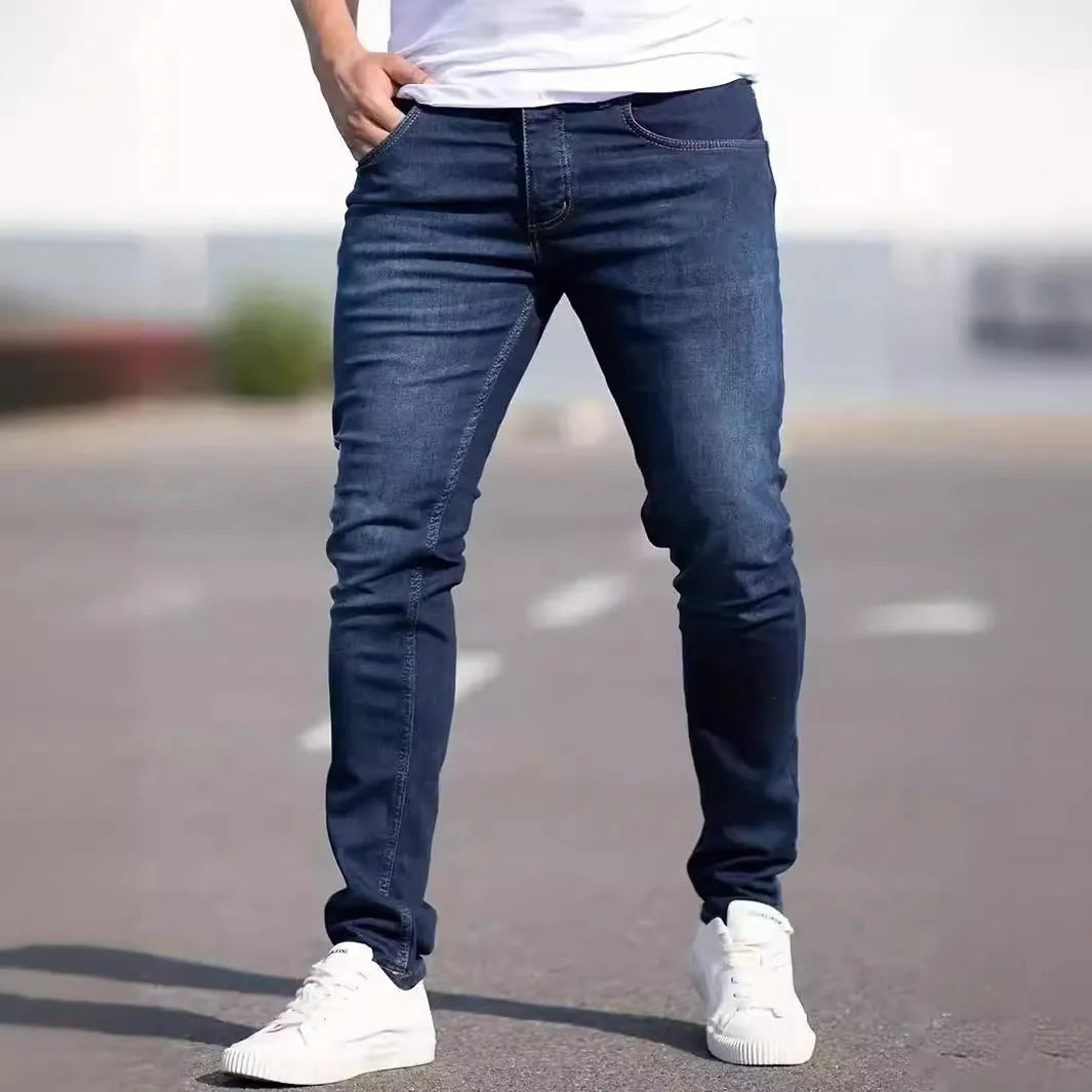 Man wearing dark blue slim fit skinny jeans with a mid-rise waist and zipper fly.