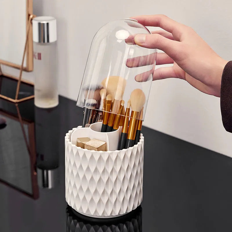 White rotating acrylic makeup brush holder with transparent dust cover on desktop.