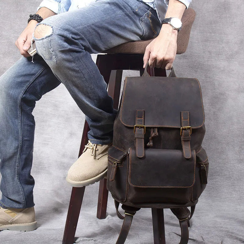 Brown leather backpack with double shoulder straps and denim lining interior