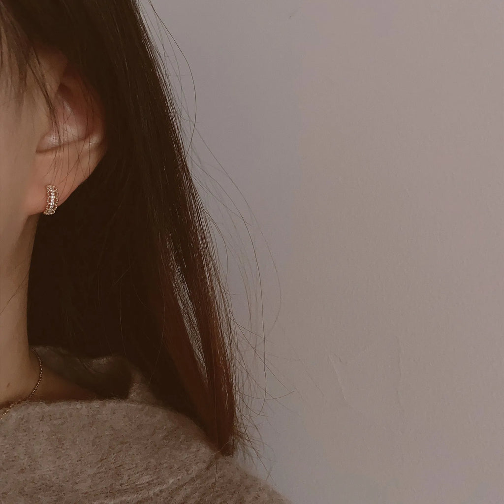 Small lace pattern ear clips in gold or platinum colour on ear model
