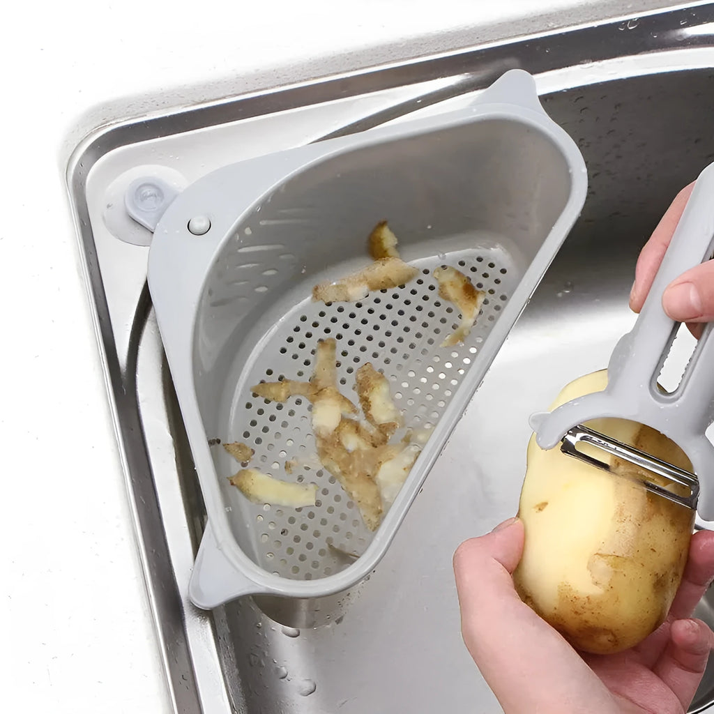 Beige plastic triangle kitchen sink rack holding a sponge and soap, hanging from a faucet.