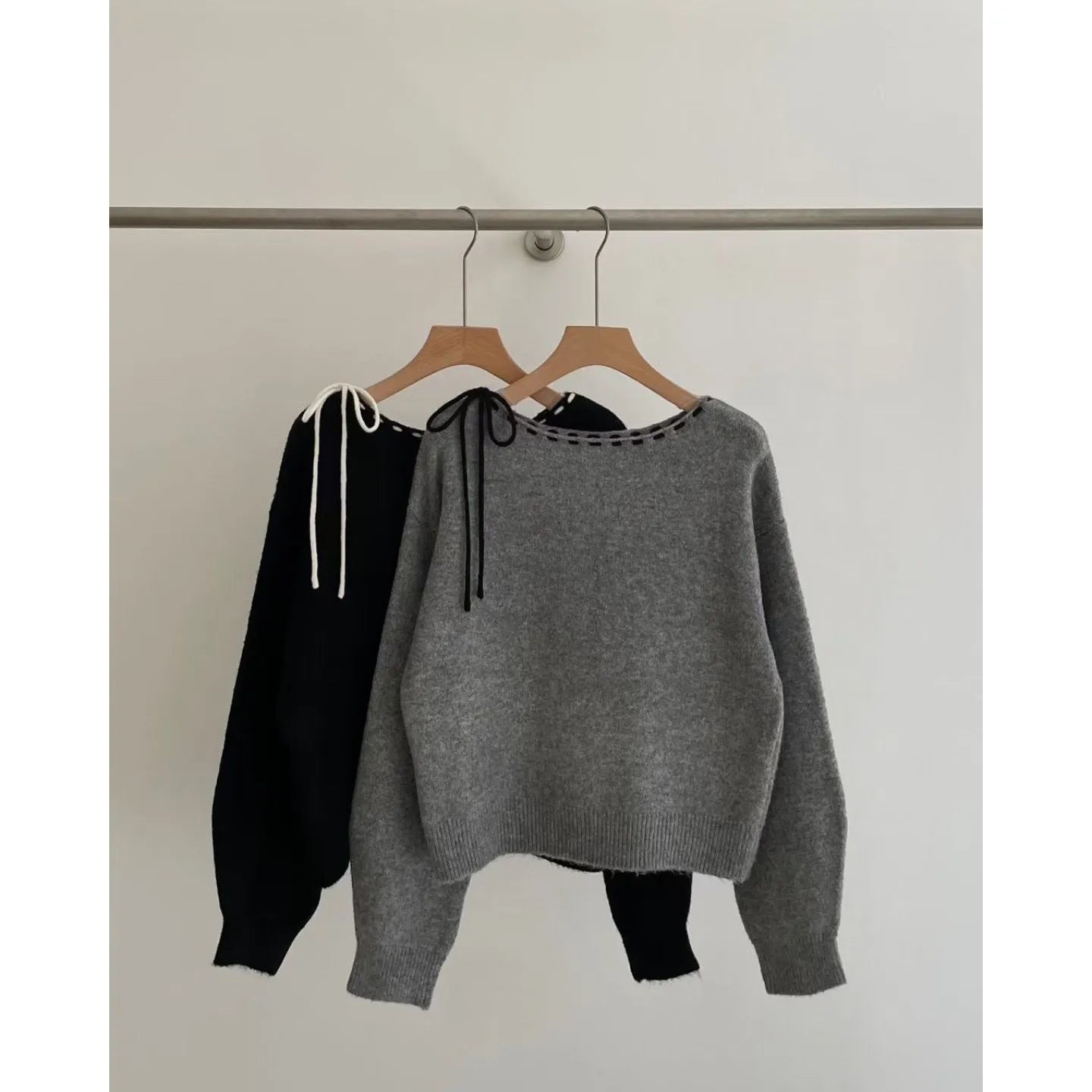 Grey loose-fitting women's long-sleeve knitwear pullover on a hanger.