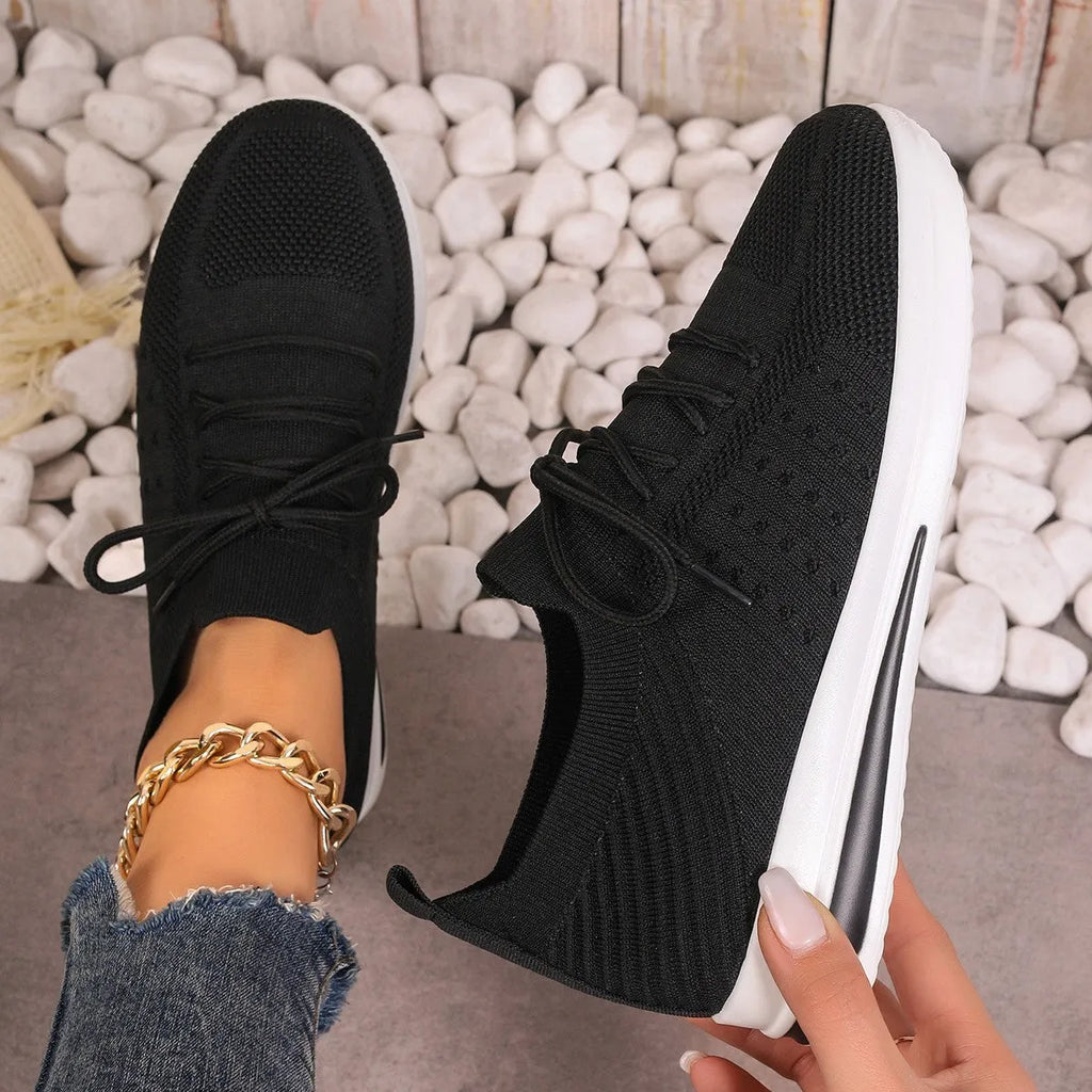 Women's low-top casual sneakers in red with front lace-up and round toe on a plain background.