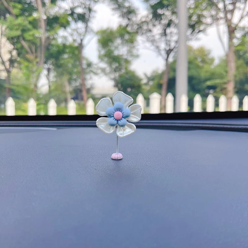 Small blue plastic swing ornament for car dashboard decoration, shown next to a ruler showing 50mm size.