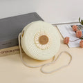 Round woven raffia crossbody bag with floral accents in 16cm diameter for mobile phones