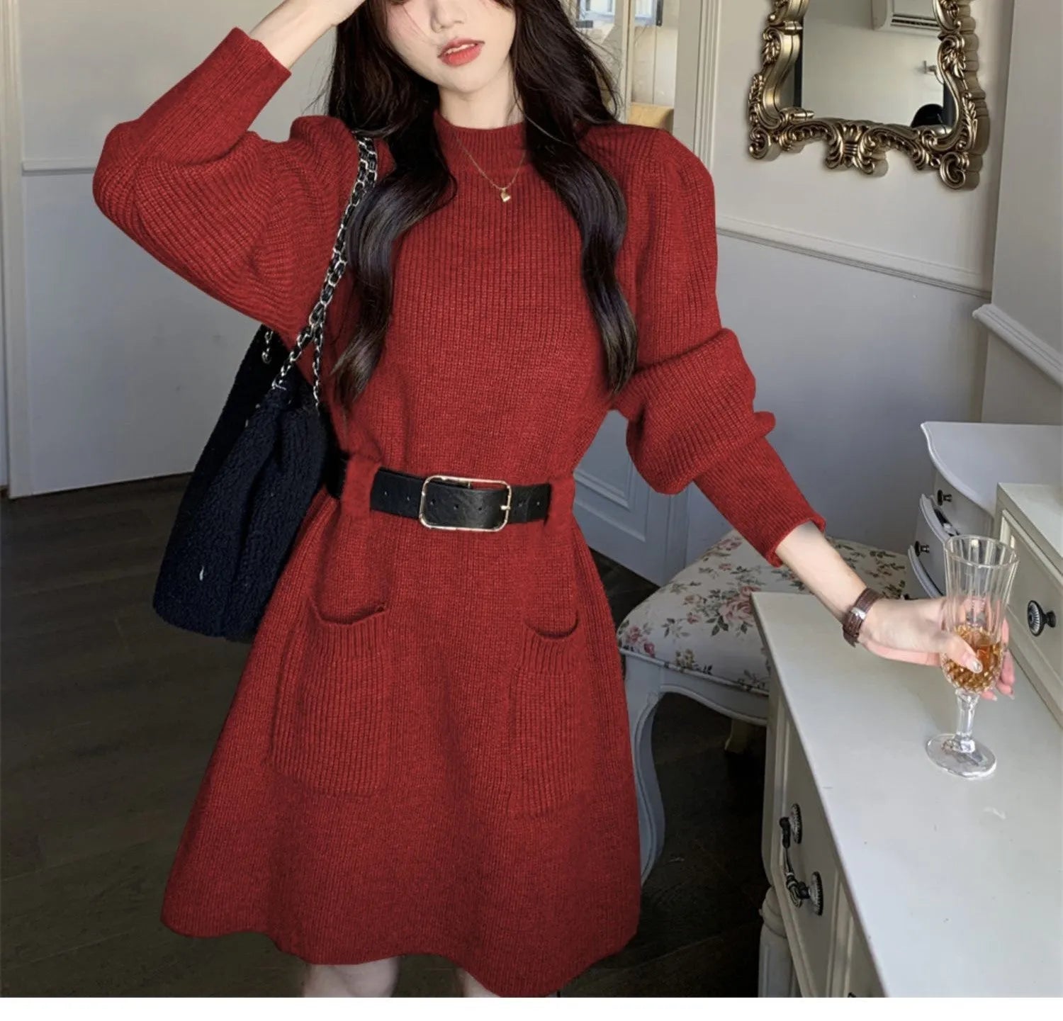 Long sleeve loose knitted dress for women in beige with a black belt, shown on a hanger.