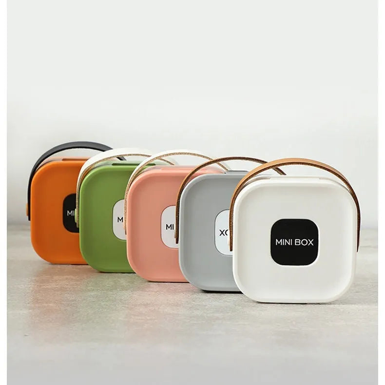 Medium-sized solid colour portable storage box for organising data cables and a Bluetooth headset.