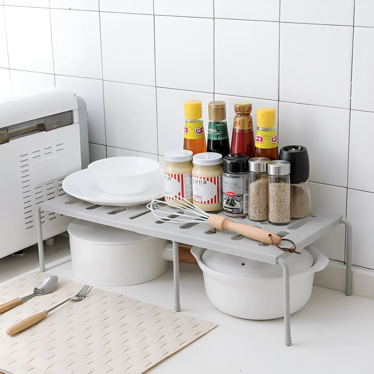 Retractable ABS rack with hollow grid design for kitchen, living room, or bathroom storage, available in grey or white