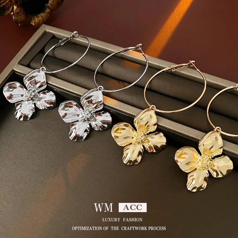 A pair of vintage-style metal flower earrings with a silver needle and geometric design in a gold or silver colour.