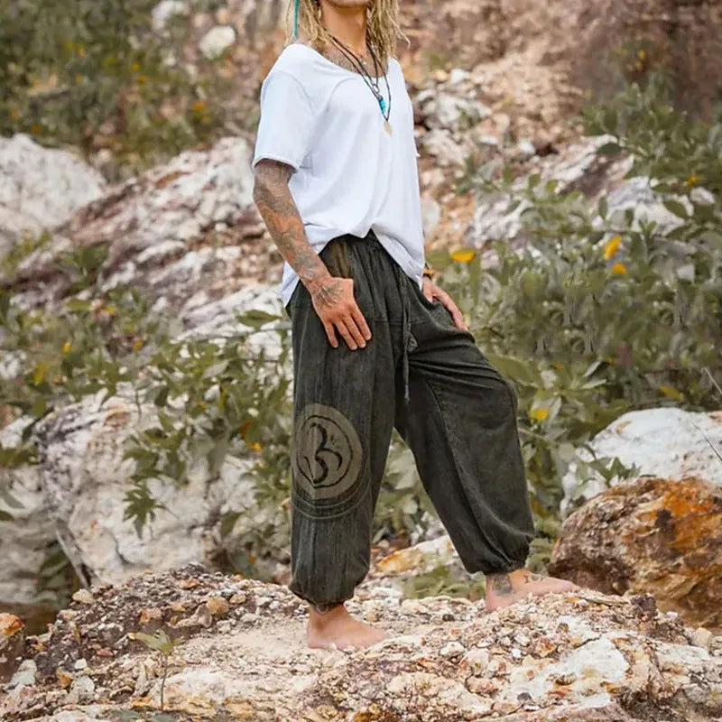 Dark green men's trousers with ethnic pattern design showing ankle-tied detail and mid-waist fit