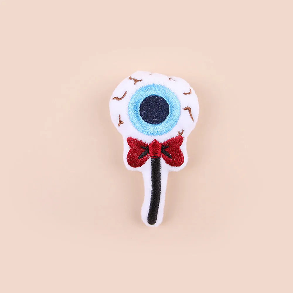 Small plush cat teaser wand with colourful eyes, candy and skull shaped attachments