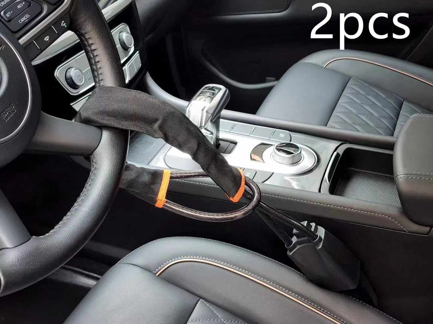 Red car steering wheel lock with iron cable secured around a steering wheel.