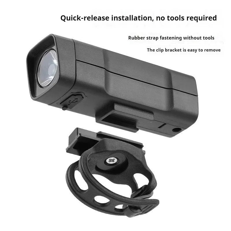 Black USB rechargeable bicycle headlight with quick-release strap mounted on bike handlebars.