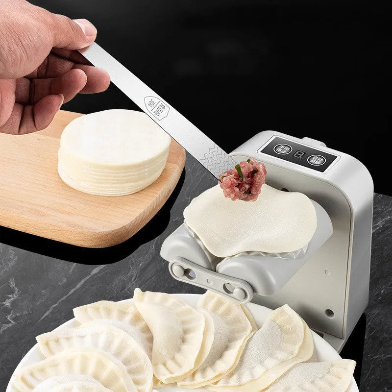 White automatic electric dumpling maker machine with USB charging cable on a kitchen counter