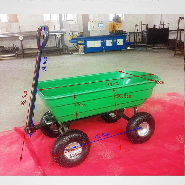 Green four-wheel plastic dump truck with a large cargo bed, shown on grass.