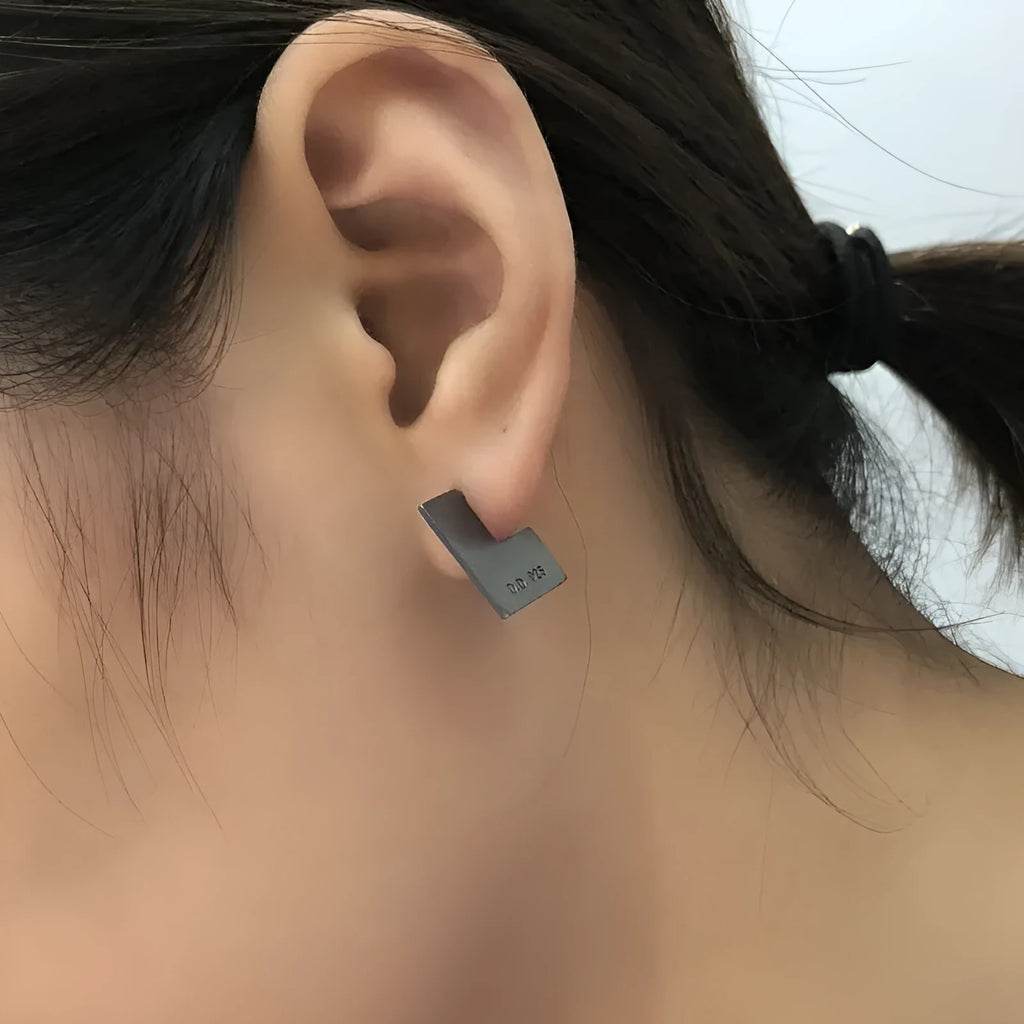 Oxidised black sterling silver square geometric earrings on a white background.