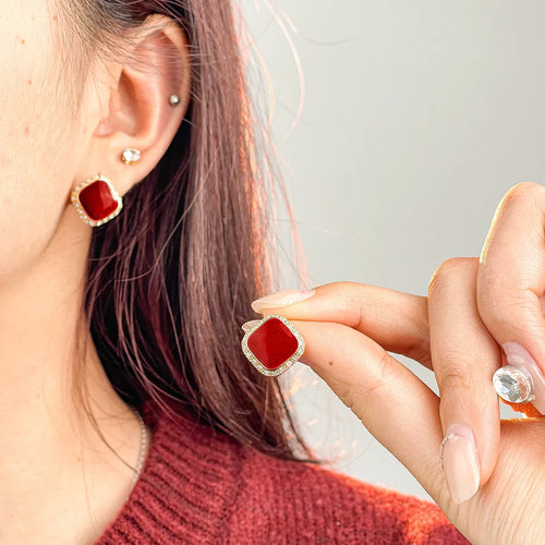 A pair of red geometric square alloy earrings with an inlaid plate design, showing front view.