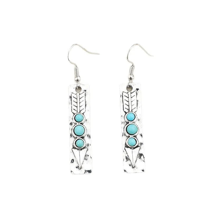 Silver geometric drop earrings with turquoise inlaid accents on a plain background