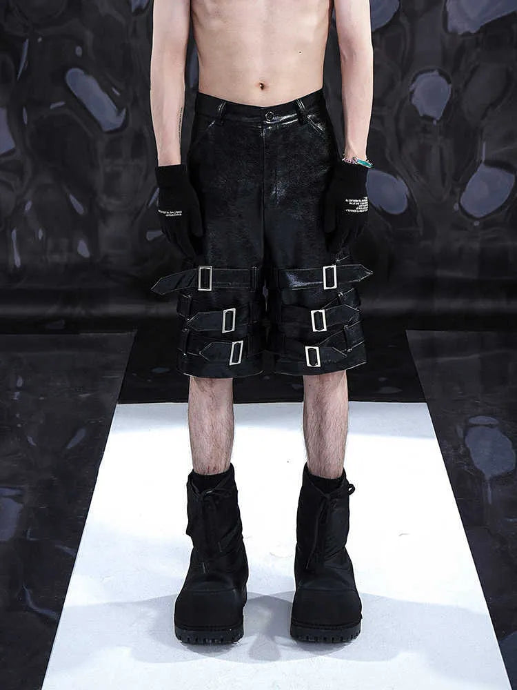 Man's black PU leather-look cropped shorts with stretch spandex material on a neutral background.