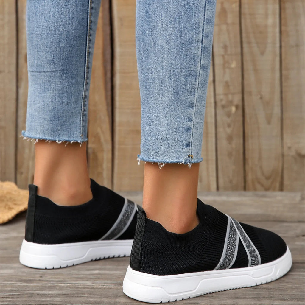 Women's black flyknit mesh outdoor shoes with flat rubber sole and tassel detail.