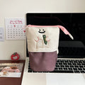 Brown collapsible pencil case with cartoon design, shown open and closed