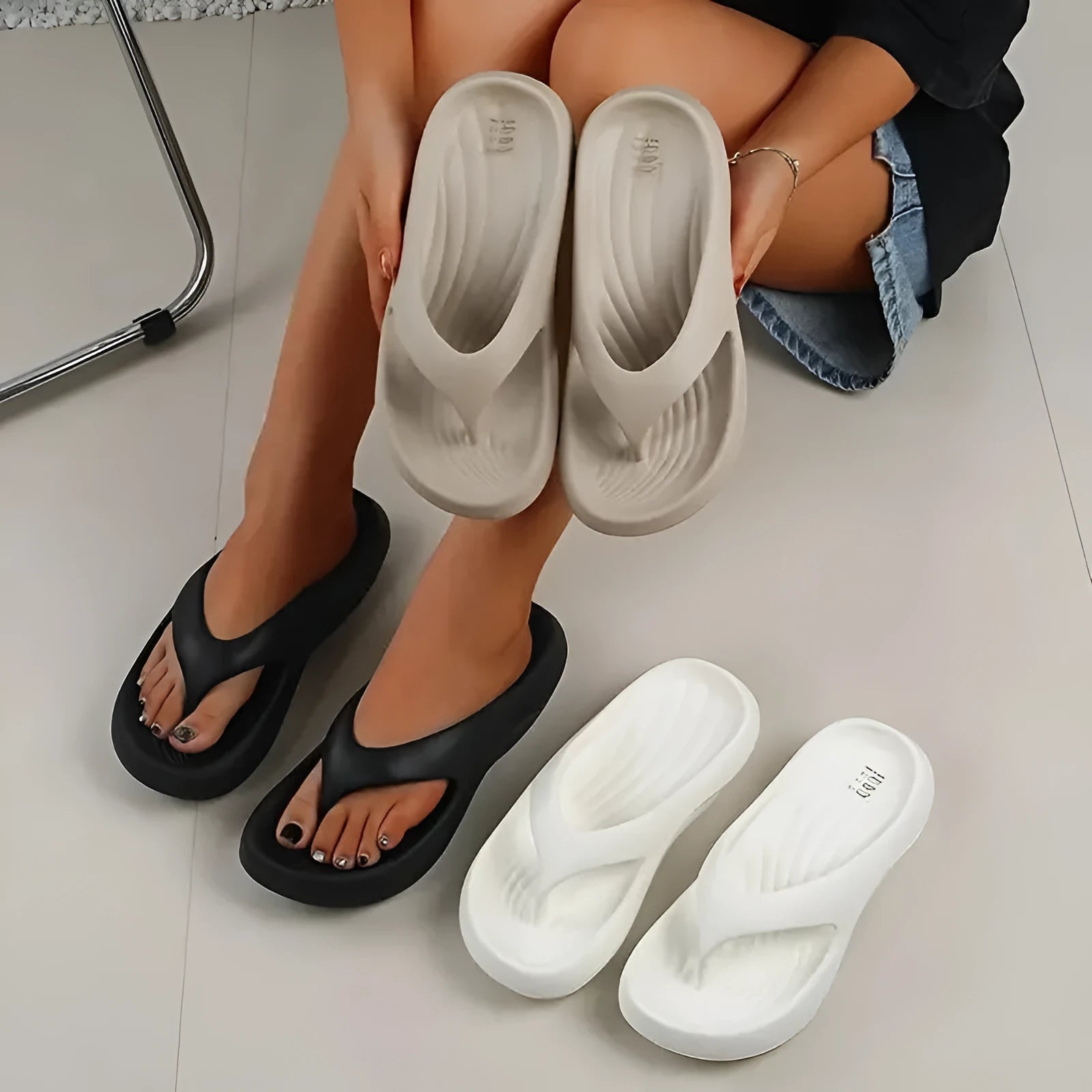 Women's black EVA flip flops with thick sole and non-slip tread on a plain background.