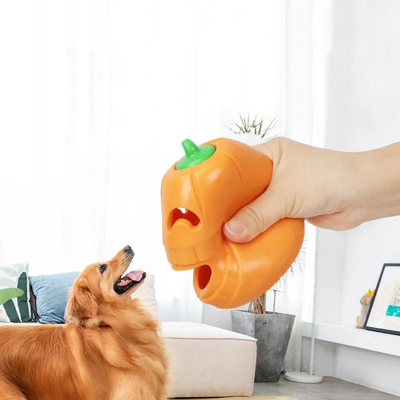 Orange Halloween pumpkin-shaped dog chew toy with a treat-dispensing funnel hole.