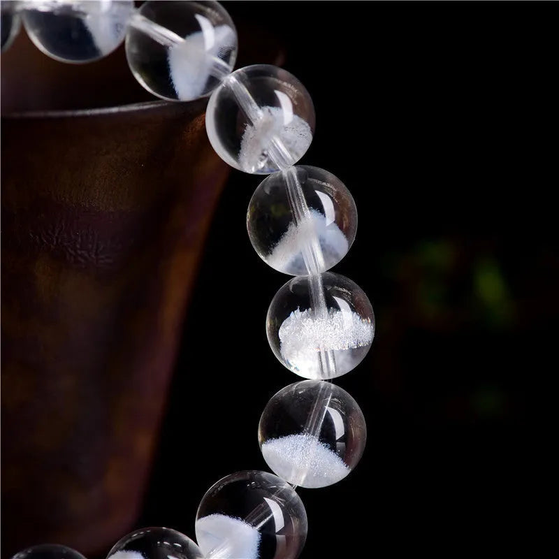 Women's natural white crystal bracelet with a pyramid charm and ruyi charm, showing spherical beads.