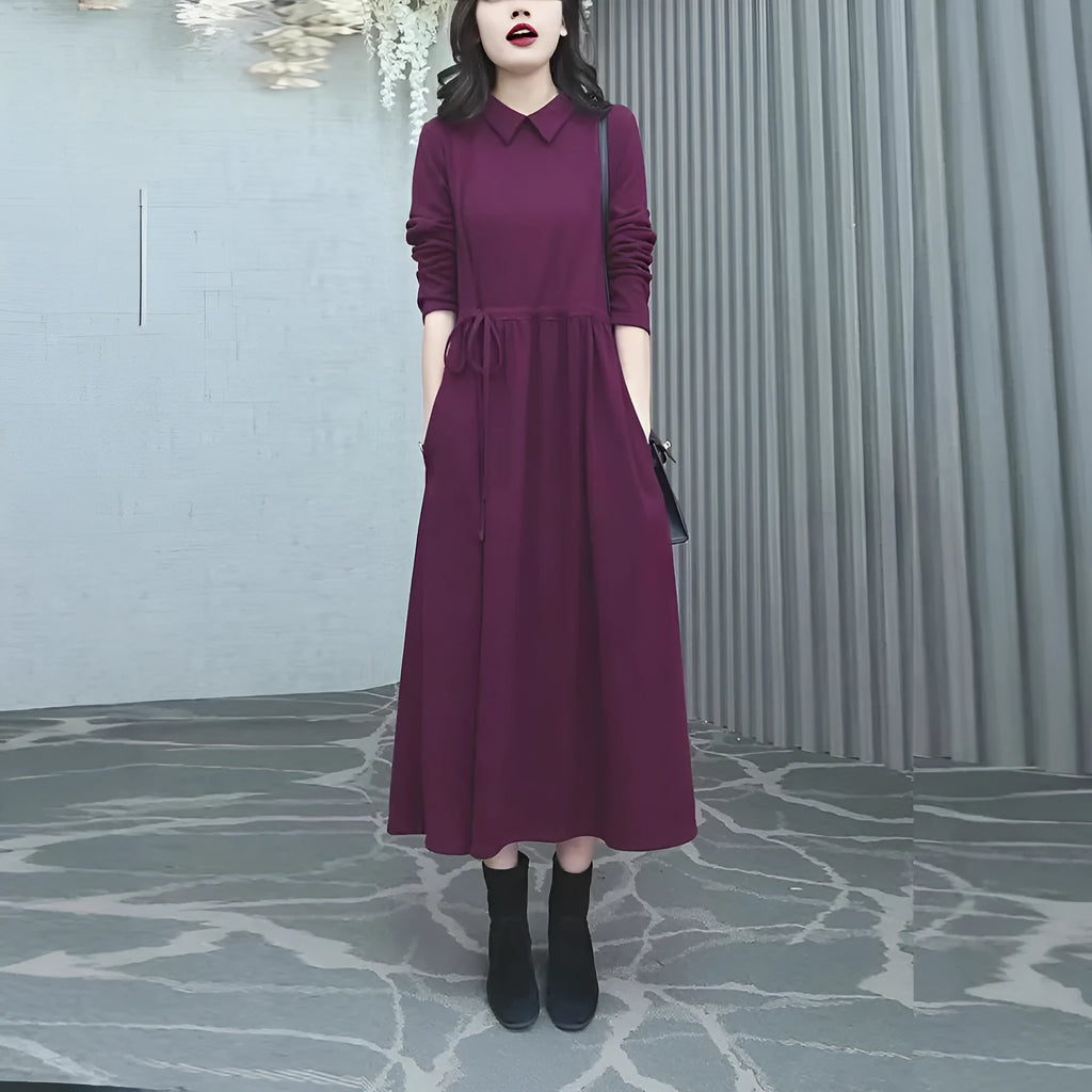 Purplish red women's long-sleeve maxi dress with extra-long cuffs and urban commute style on a hanger.