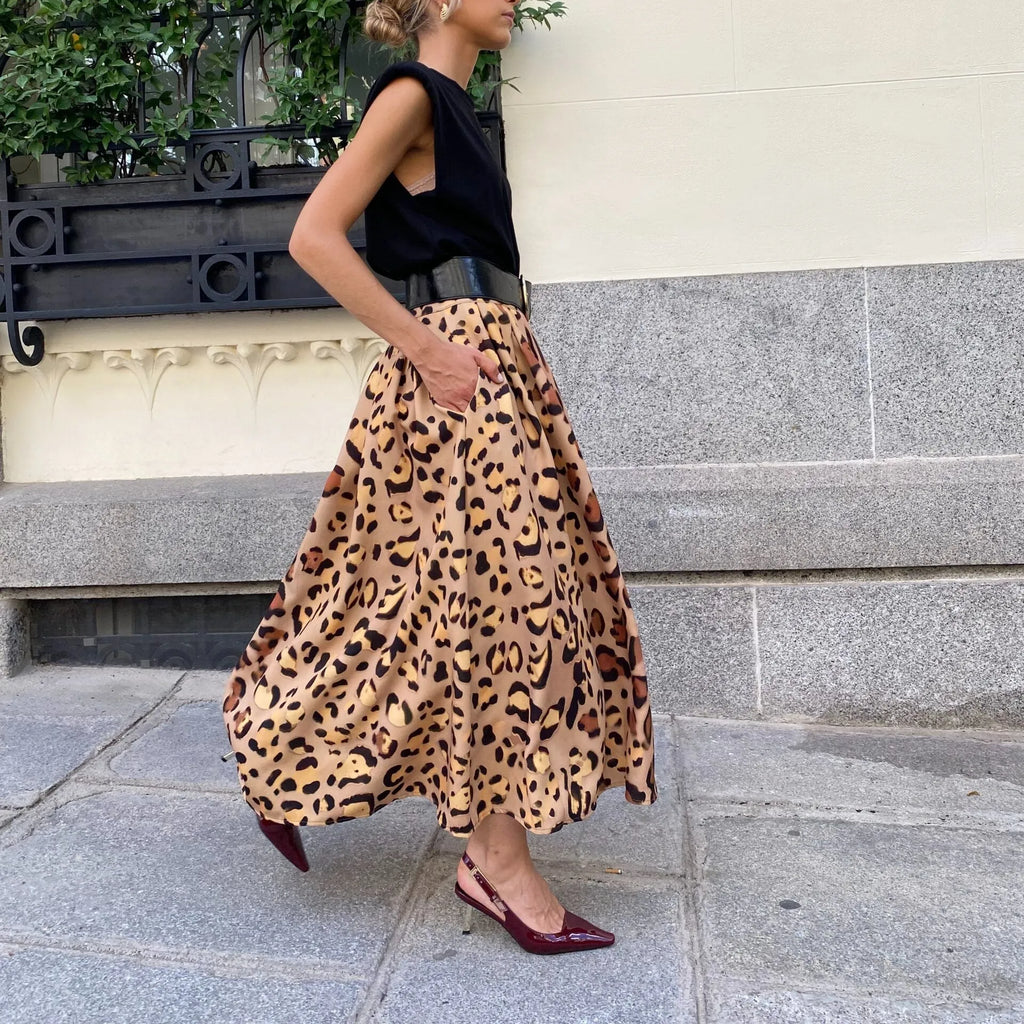 Brown leopard print women's long A-line skirt with a defined waist and wide, flowing hem on a neutral background.