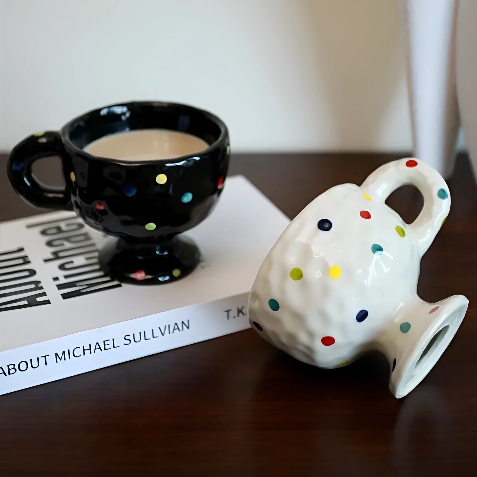 A hand-pinched ceramic mug with an irregular shape in a solid colour, shown on a table.