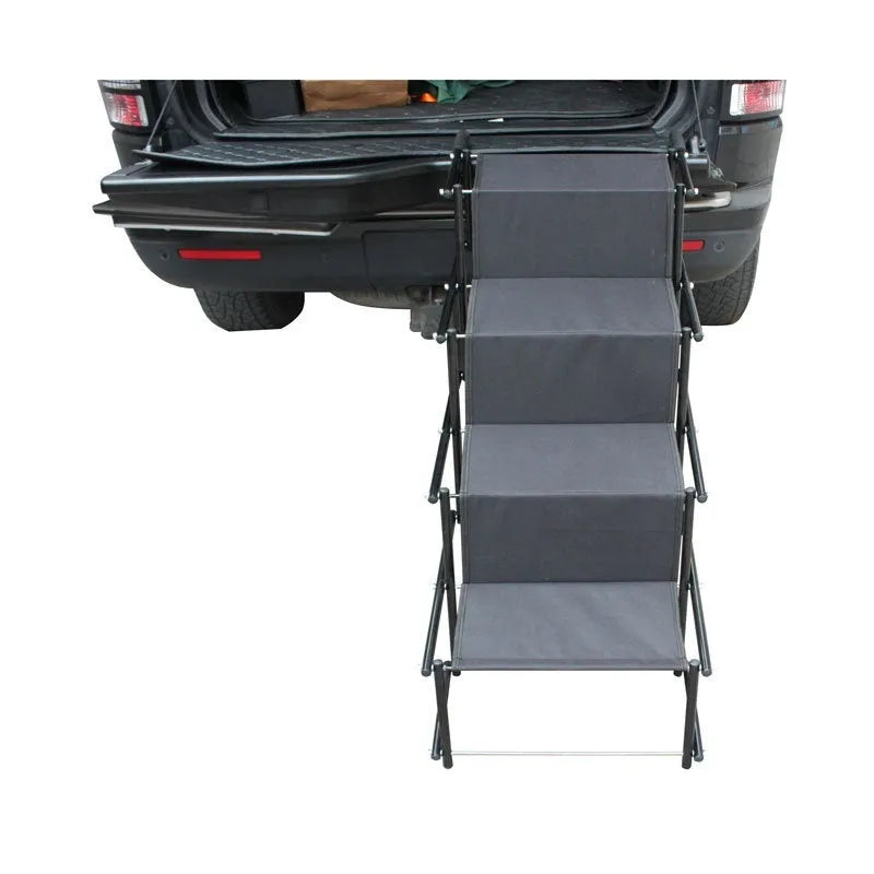 Folding four-step stainless steel dog ladder in navy blue, set up at a car tailgate.