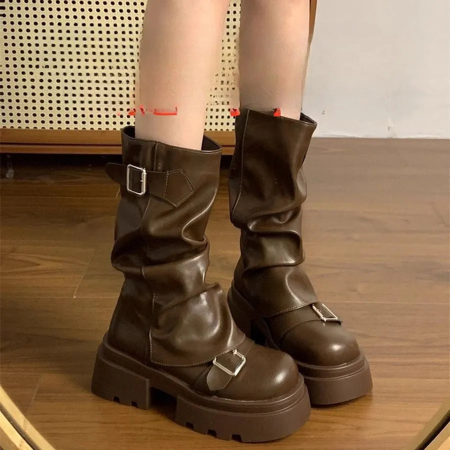 Brown retro platform boots with wedge heel, side zipper, round toe, and belt buckle detail on a white background