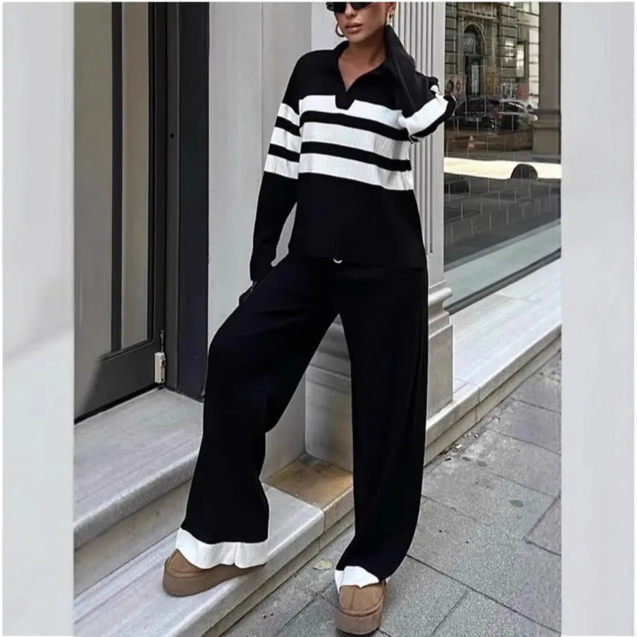 Woman wearing a black and white striped long-sleeve polo shirt and matching black casual trousers from a two-piece knit set.