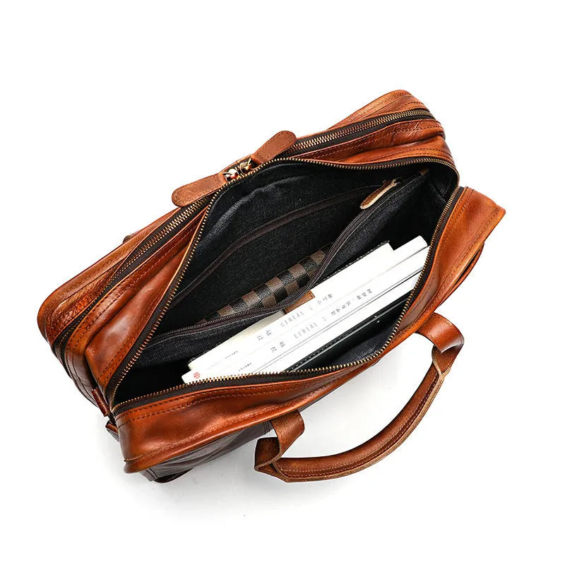 Brown vintage leather men's briefcase showing internal organiser pockets and laptop sleeve.