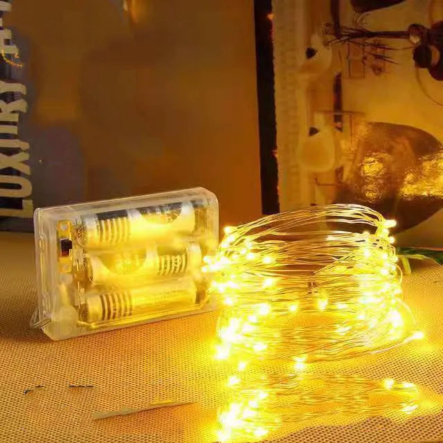 Copper wire string light with warm white LEDs wrapped around a wooden post