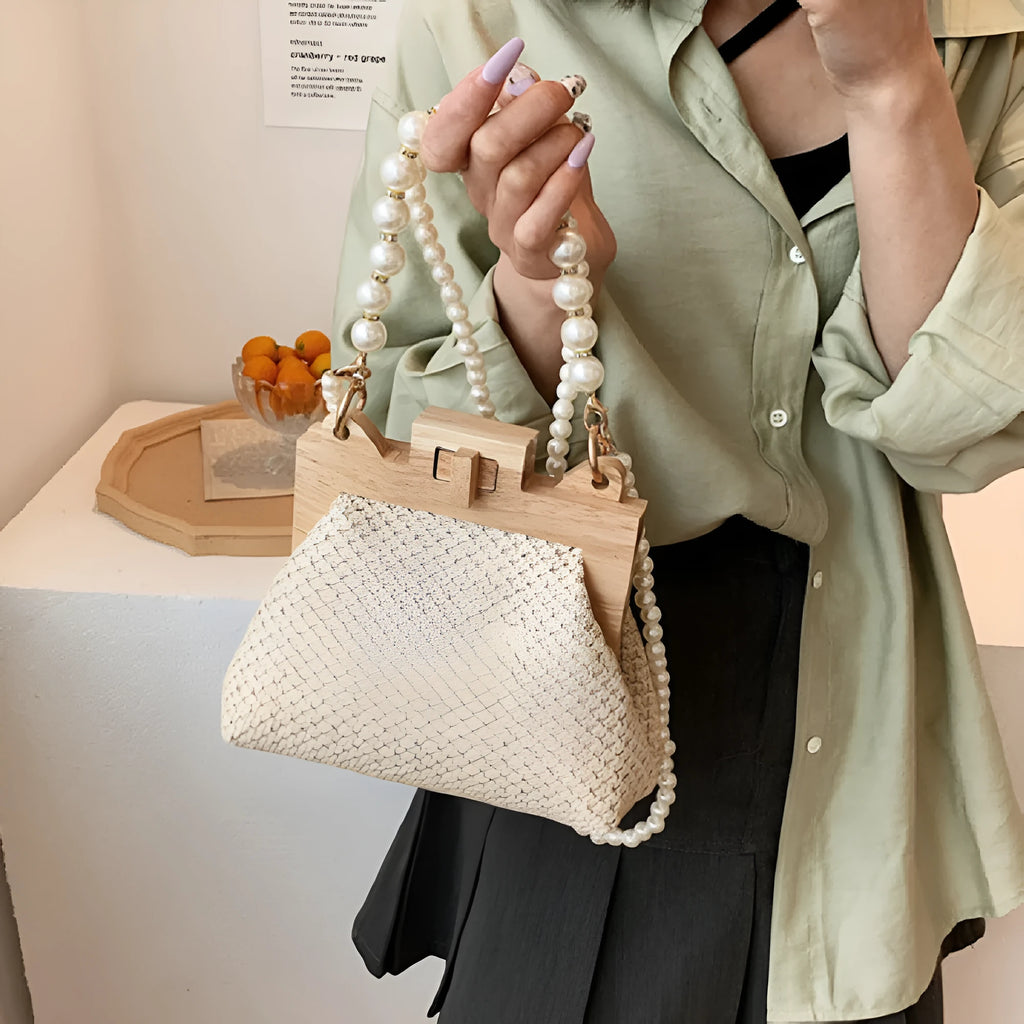 Women's woven straw shoulder bag with pearl chain strap showing internal organisation compartments