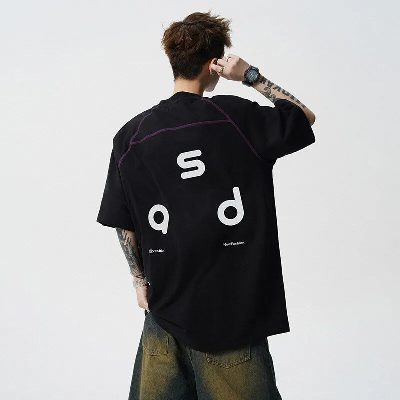 A loose-fit black cotton T-shirt with a white letter print on the front, showing a round neck and short sleeves.