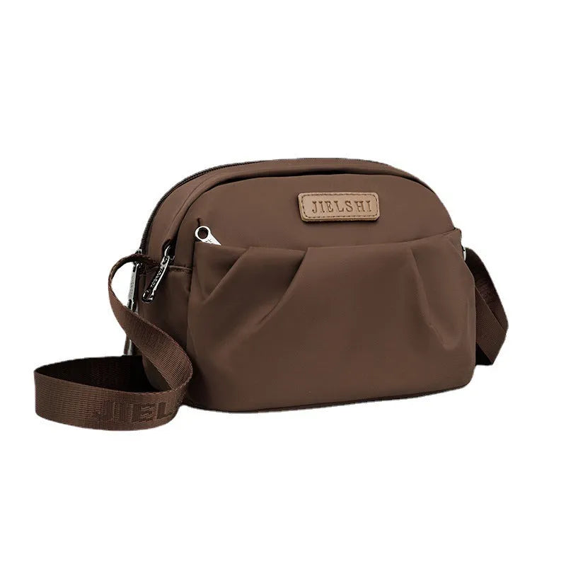 Pleated Oxford cloth horizontal messenger bag in cangling green, showing cross-body strap and external pocket.