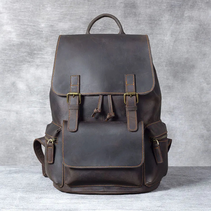 Brown leather backpack with double shoulder straps and denim lining interior