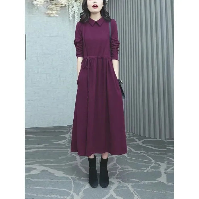 Purplish red women's long-sleeve maxi dress with extra-long cuffs and urban commute style on a hanger.